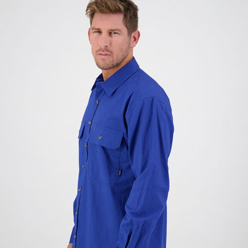 Model wearing Swanndri Byron Men’s Long Sleeve Shirt in Electric Blue, showing the side profile and relaxed workwear fit.