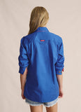 Rear view of a woman wearing the mid blue S. Kidman Camfield work shirt. The back features a straight cut with reinforced double stitching along the shoulder yoke, providing strength and freedom of movement ideal for station life or farm work.