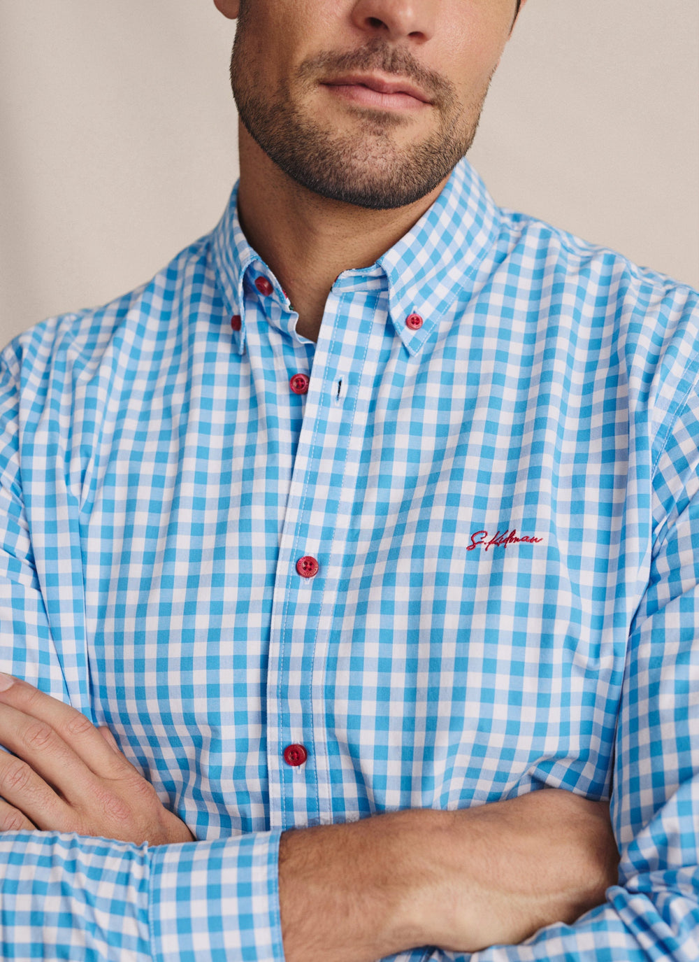 Close-up of S.Kidman Holstein Long Sleeve Shirt in Pale Blue gingham, showing red buttons, collar and embroidered chest detail.
