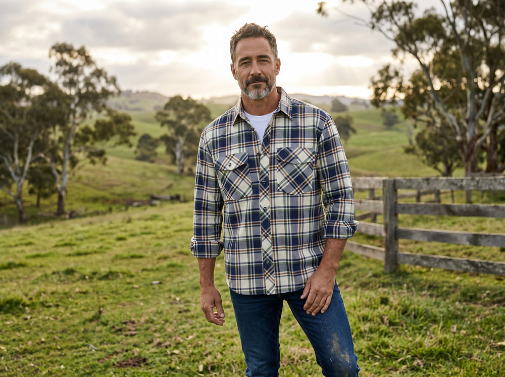 Man in a grassy field in Outback Australia wearing a Swanndri Egmont Parklands brushed cotton flannel shirt with navy green and bronze check pattern
