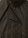 Close-up front view of Driza-Bone Kids Rider Coat showing detailed oilskin texture, storm flap, and authentic brass snap buttons.