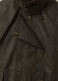 Close-up front view of Driza-Bone Kids Rider Coat showing detailed oilskin texture, storm flap, and authentic brass snap buttons.