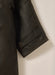Close-up of Driza-Bone Kids Rider Coat sleeve showing durable cuff stitching, weatherproof oilskin finish, and classic brass snap fastener.