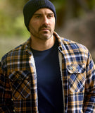 Close-up outdoor shot of Swanndri Newton Beanie blue highlighting knit texture and Swanndri logo tag.